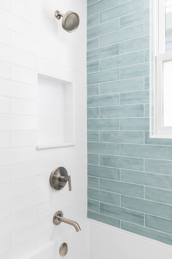 Shower with white subway tile and blue accent wall
